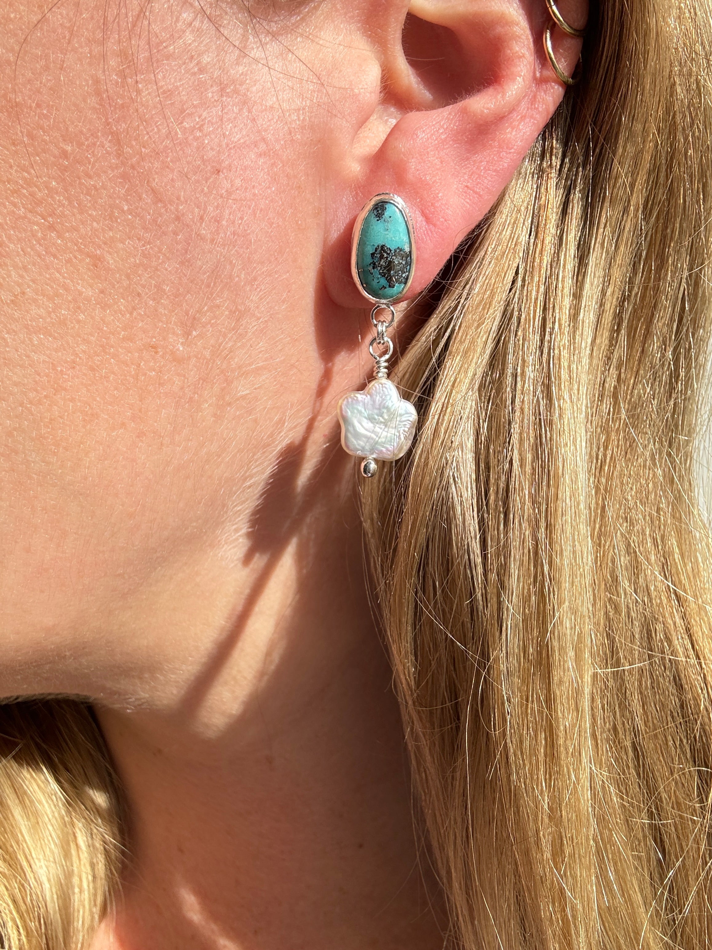 Robin's Egg Blue Kingman Turquoise set in a fine silver bezel with flower shaped pearls dangling below. The posts and ear backs are sterling silver. 