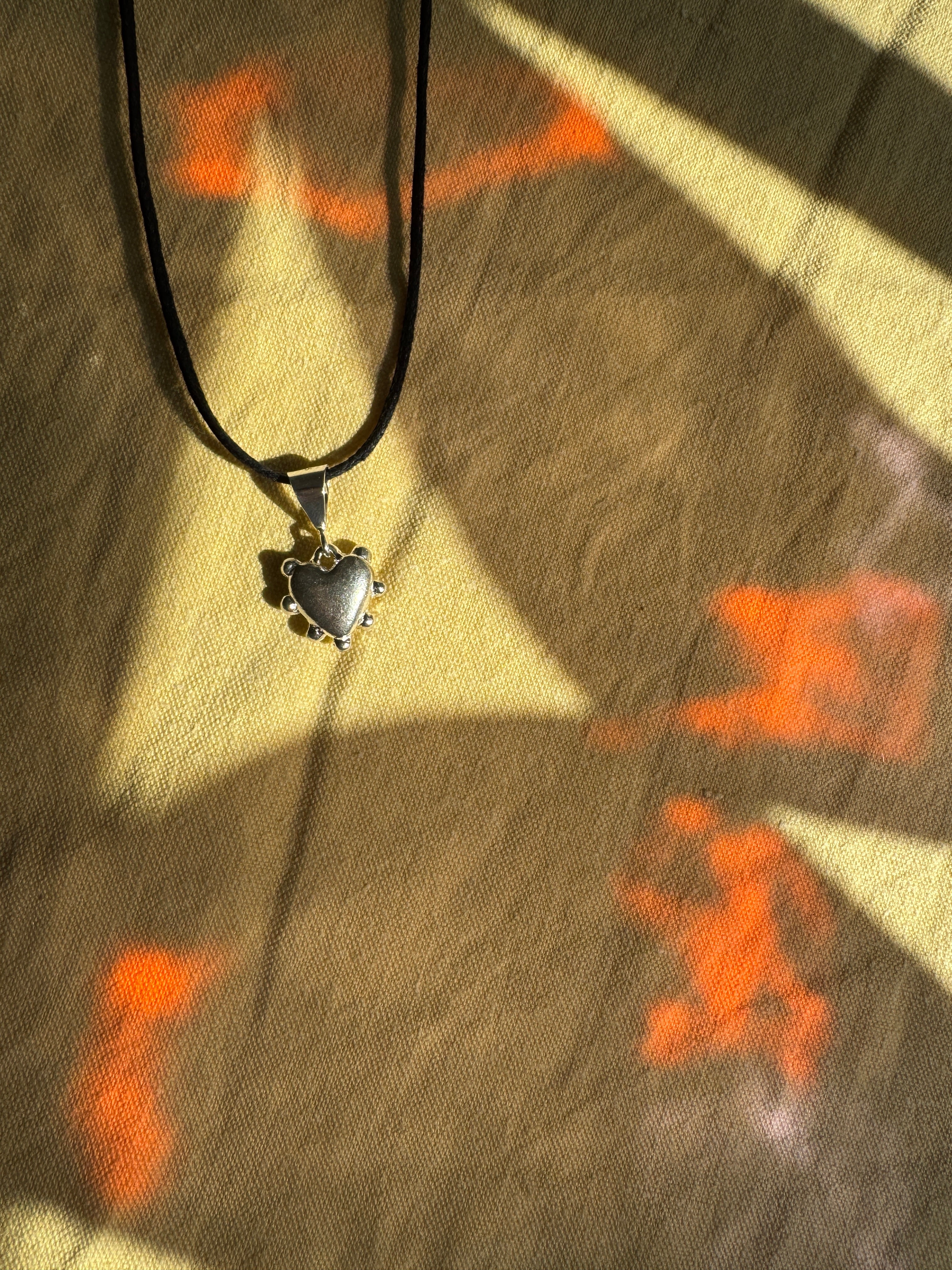 Thick sterling silver heart bordered with dots. This heart is a casting from an original mold that I created out of wax.