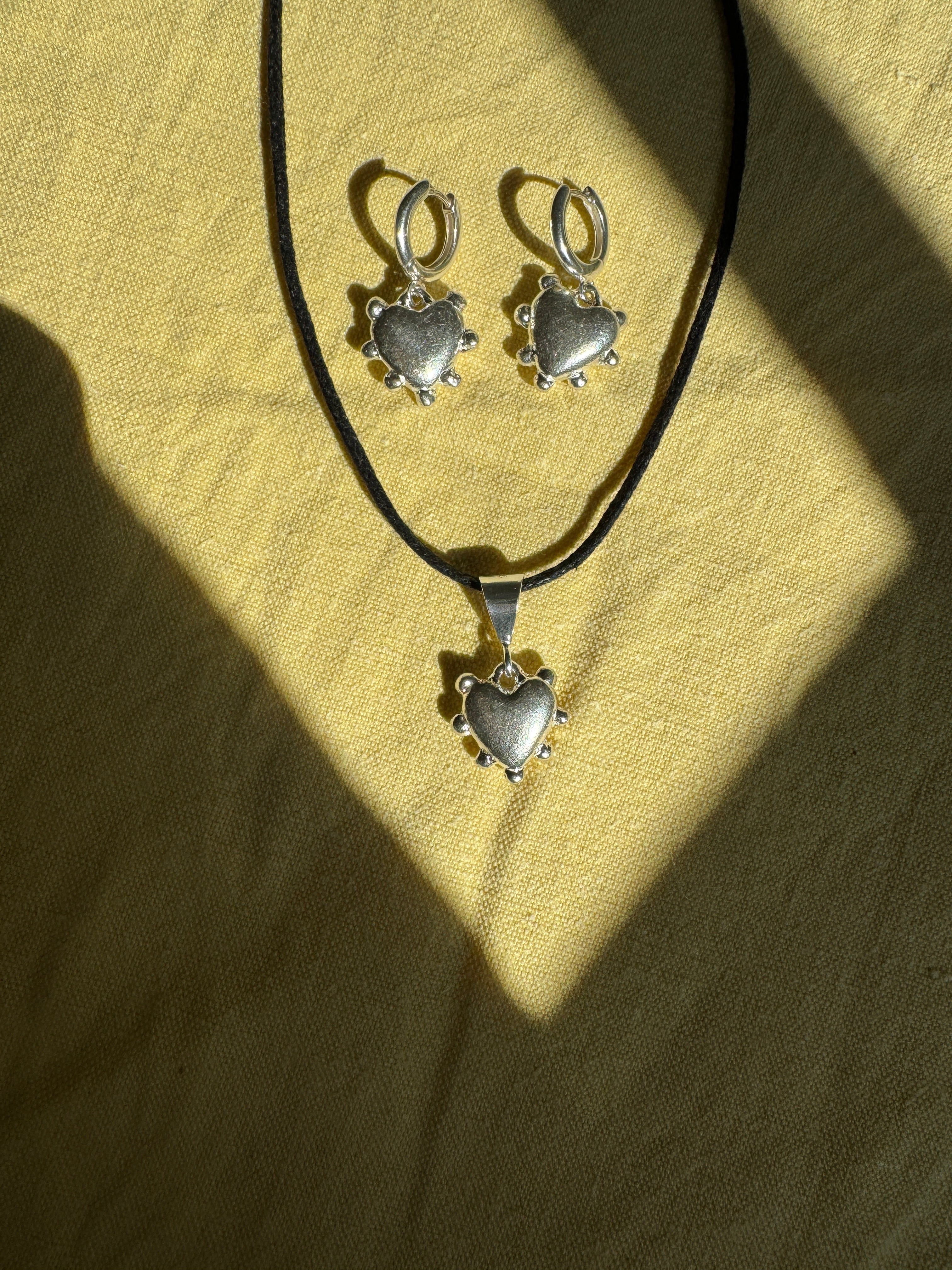 Thick sterling silver hearts bordered with dots. These are castings from an original mold that I created out of wax. These are solid silver but still light enough to wear as everyday earrings. The hoops are sterling silver as well.