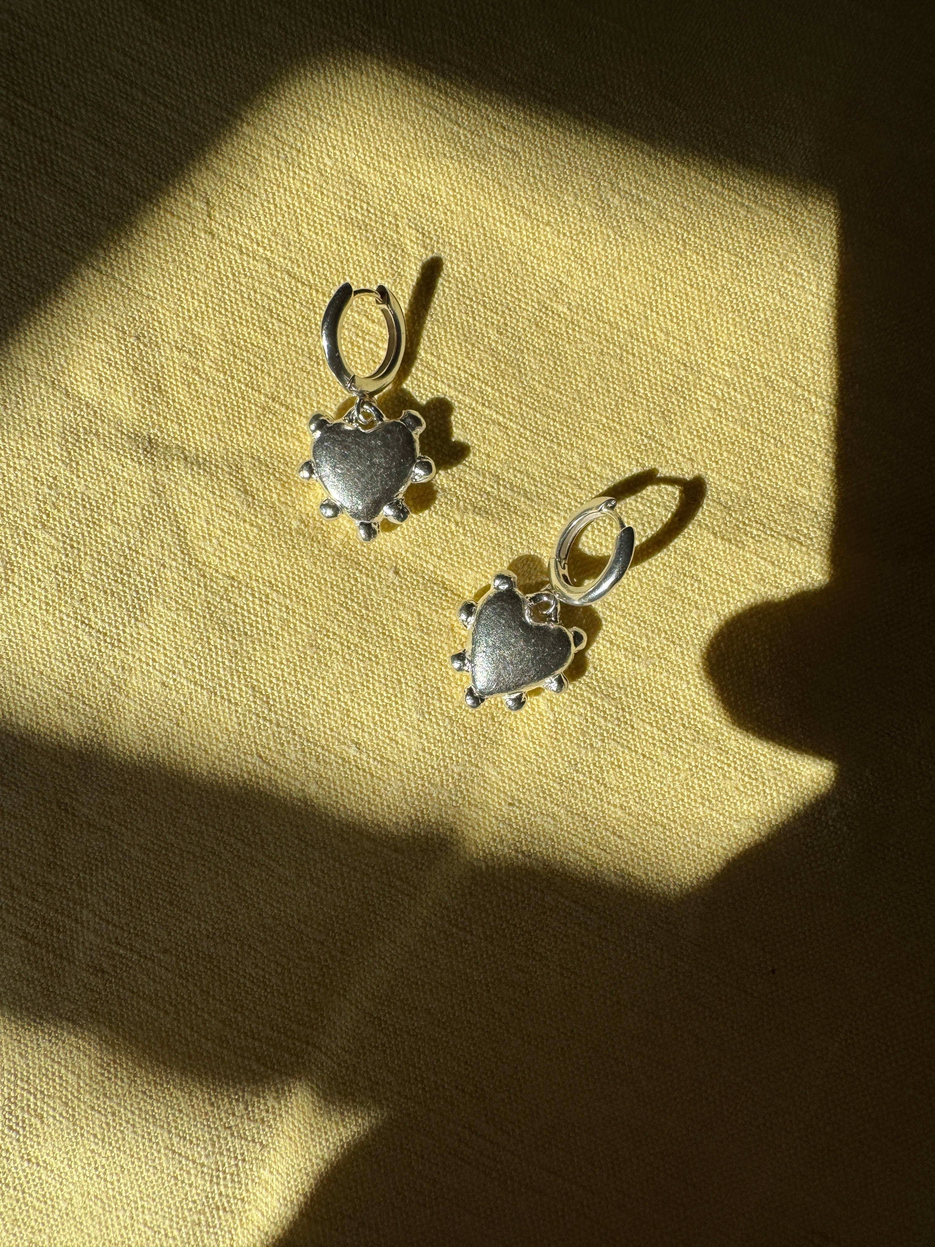 Thick sterling silver hearts bordered with dots. These are castings from an original mold that I created out of wax. These are solid silver but still light enough to wear as everyday earrings. The hoops are sterling silver as well.