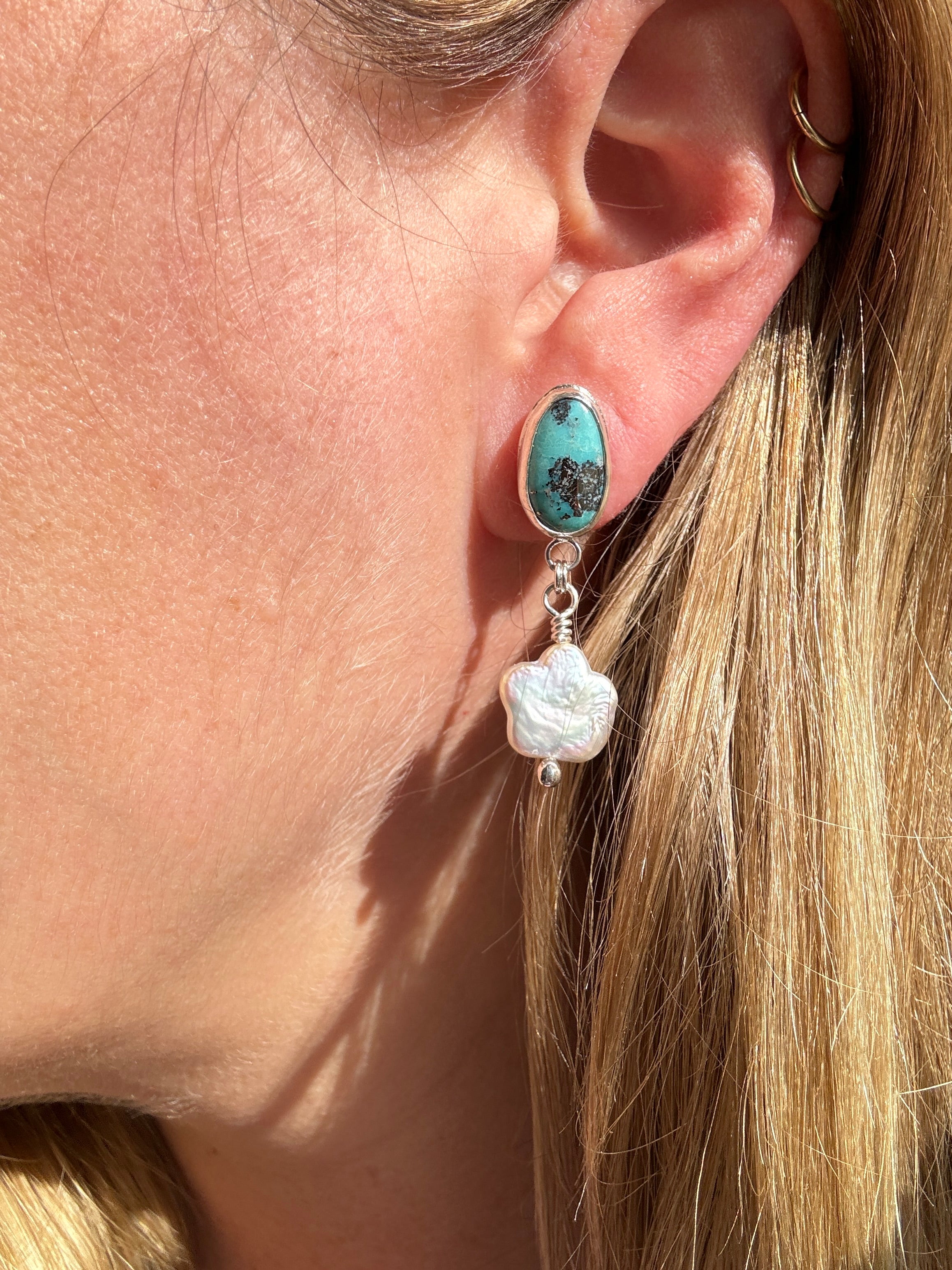 Robin's Egg Blue Kingman Turquoise set in a fine silver bezel with flower shaped pearls dangling below. The posts and ear backs are sterling silver. 