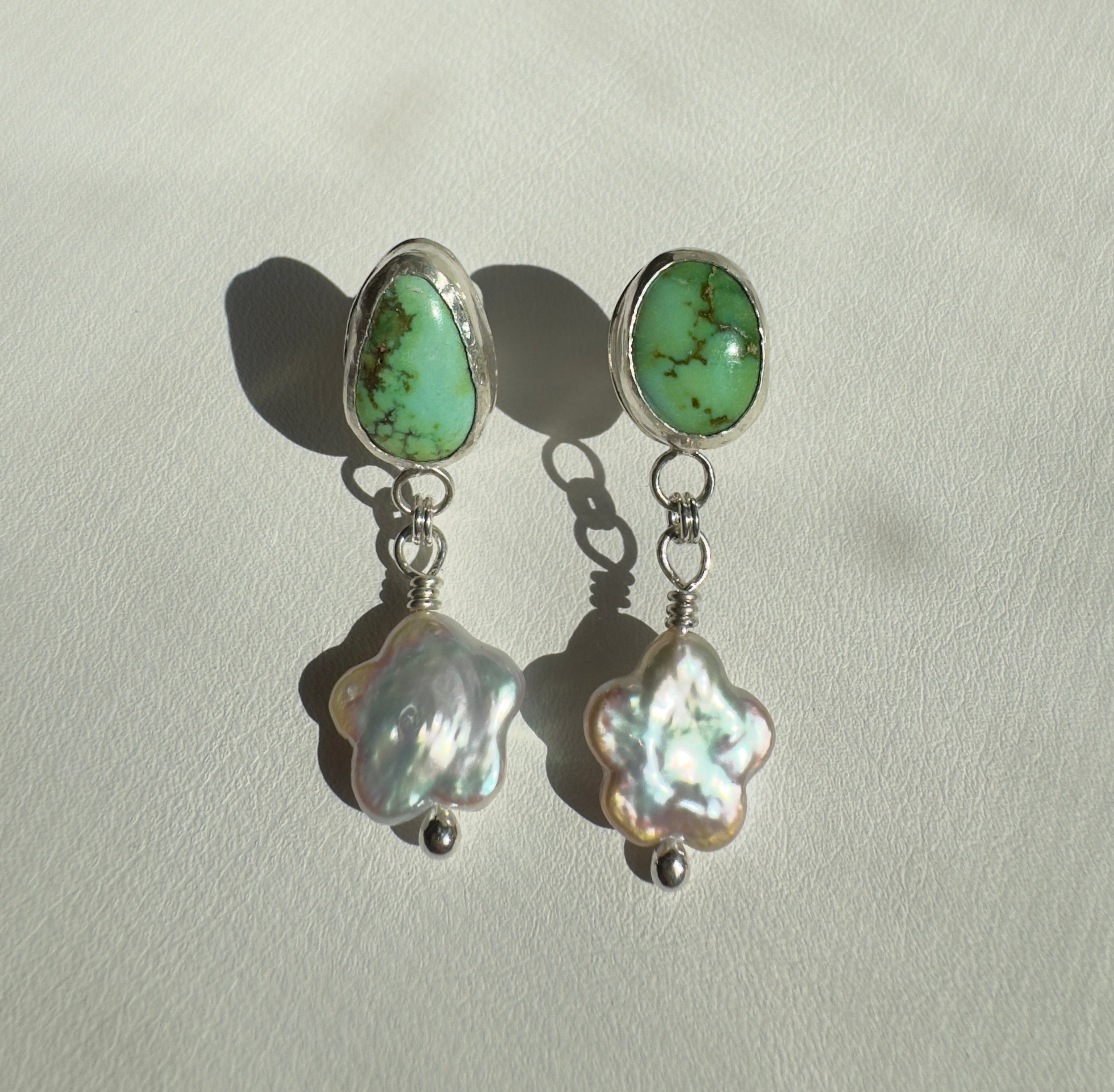 Verde Valley Turquoise set in a fine silver bezel with flower shaped pearls dangling below. The posts and ear backs are sterling silver.