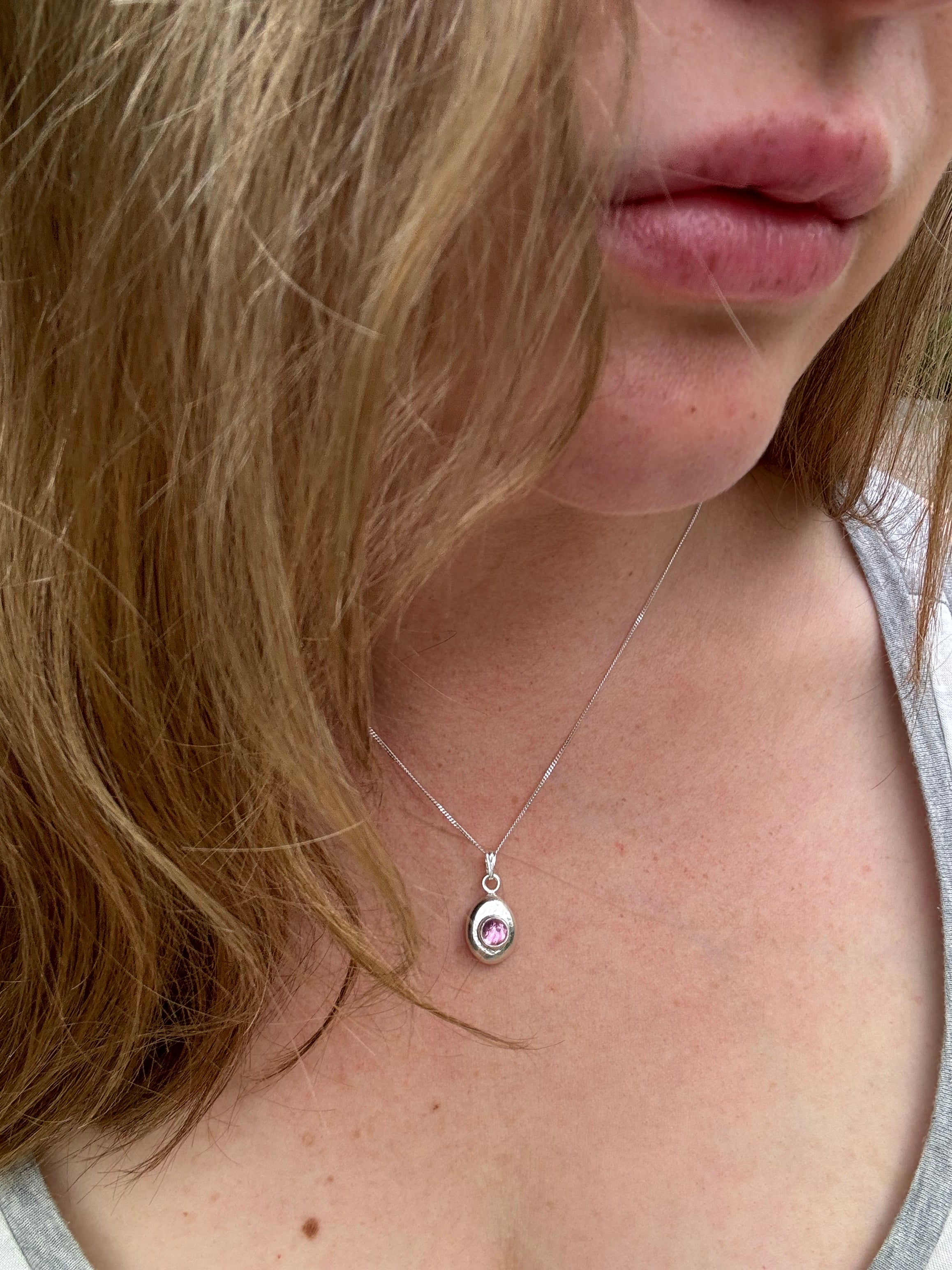 6mm Pink Sapphire (lab created) on a hand forged nugget of sterling silver. Choose between a 16” or 18” sterling silver diamond cut curb chain.