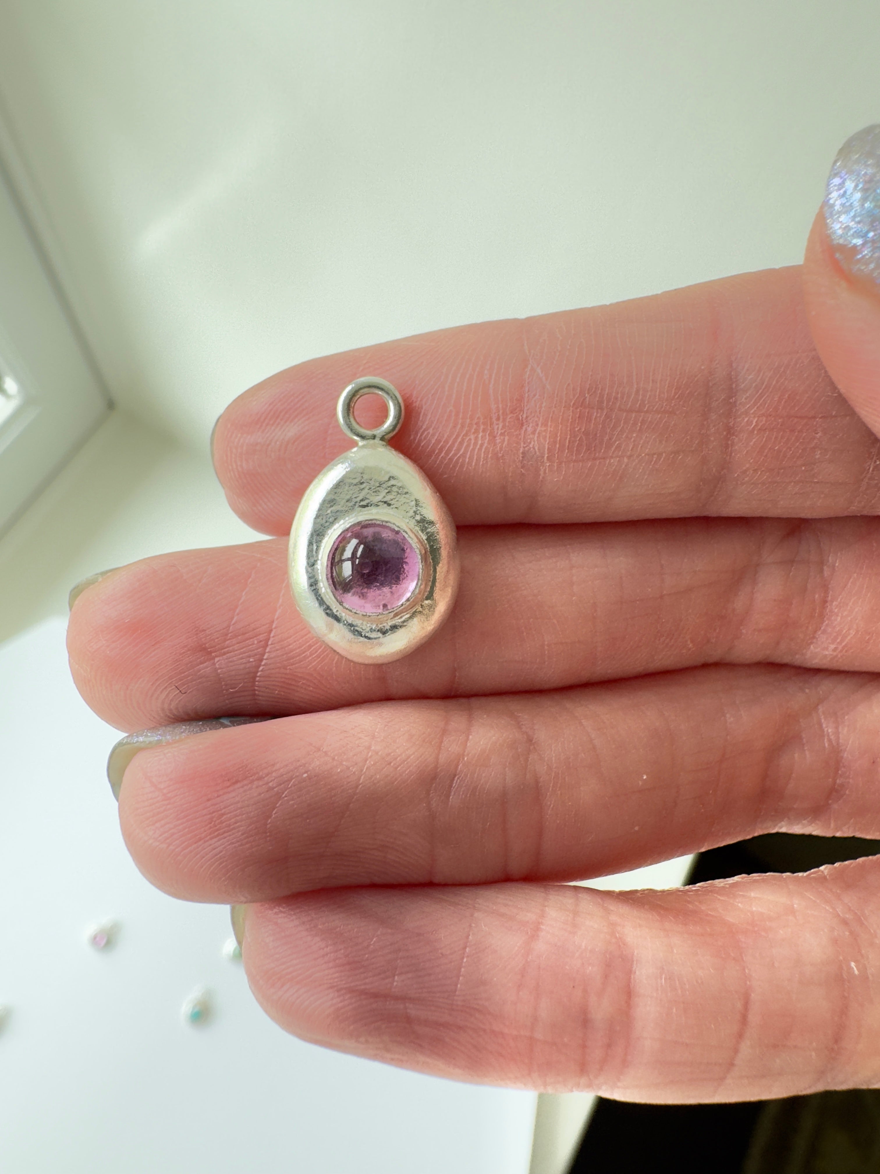 6mm Pink Sapphire (lab created) on a hand forged nugget of sterling silver. Choose between a 16” or 18” sterling silver diamond cut curb chain.