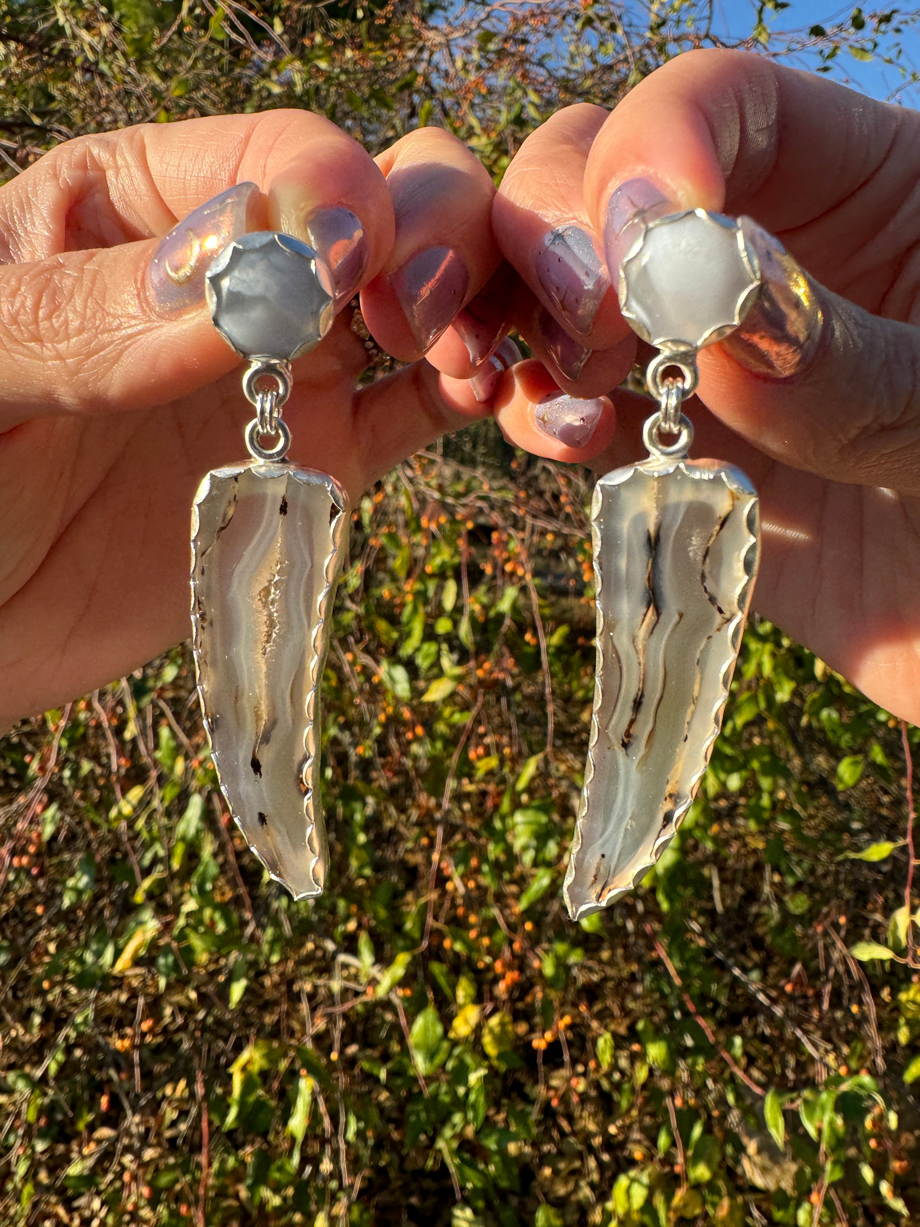 Gorgeous Montana Yellowstone Agate wrapped in fine silver and dangling from periwinkle chalcedony studs. This Montana agate was dug and cut by a Montana born female miner, making this pair extra special. These look stunning on, especially when the light hits the agate because I cut out most of the silver in the back to allow light to shine through and also keep these very lightweight and easy to wear. One of a kind pair.