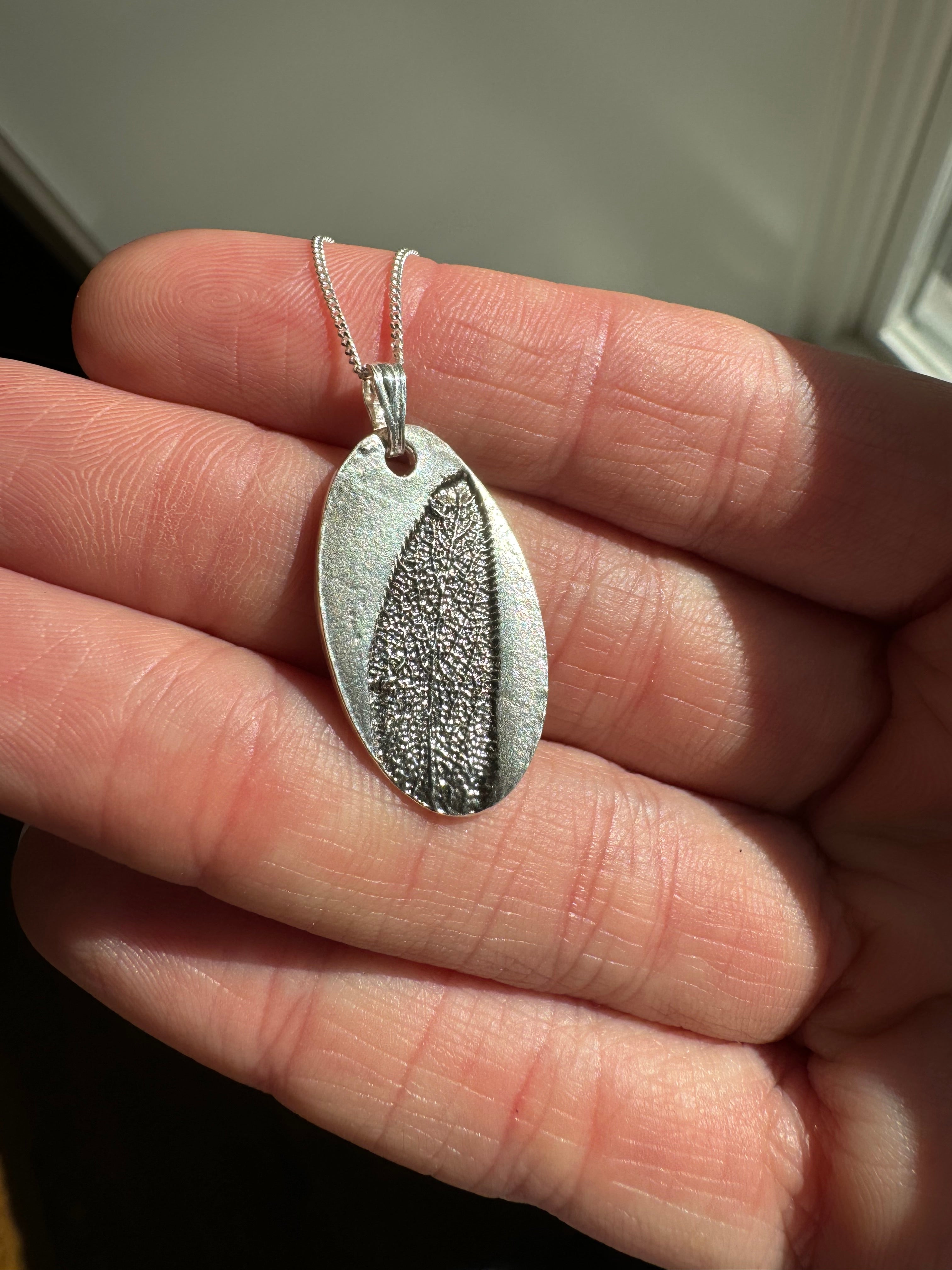 Sage imprint pendant in fine silver with a sterling silver bail. Choose between a 16" or 18" sterling silver chain. Each pendant is hand pressed and one of a kind.