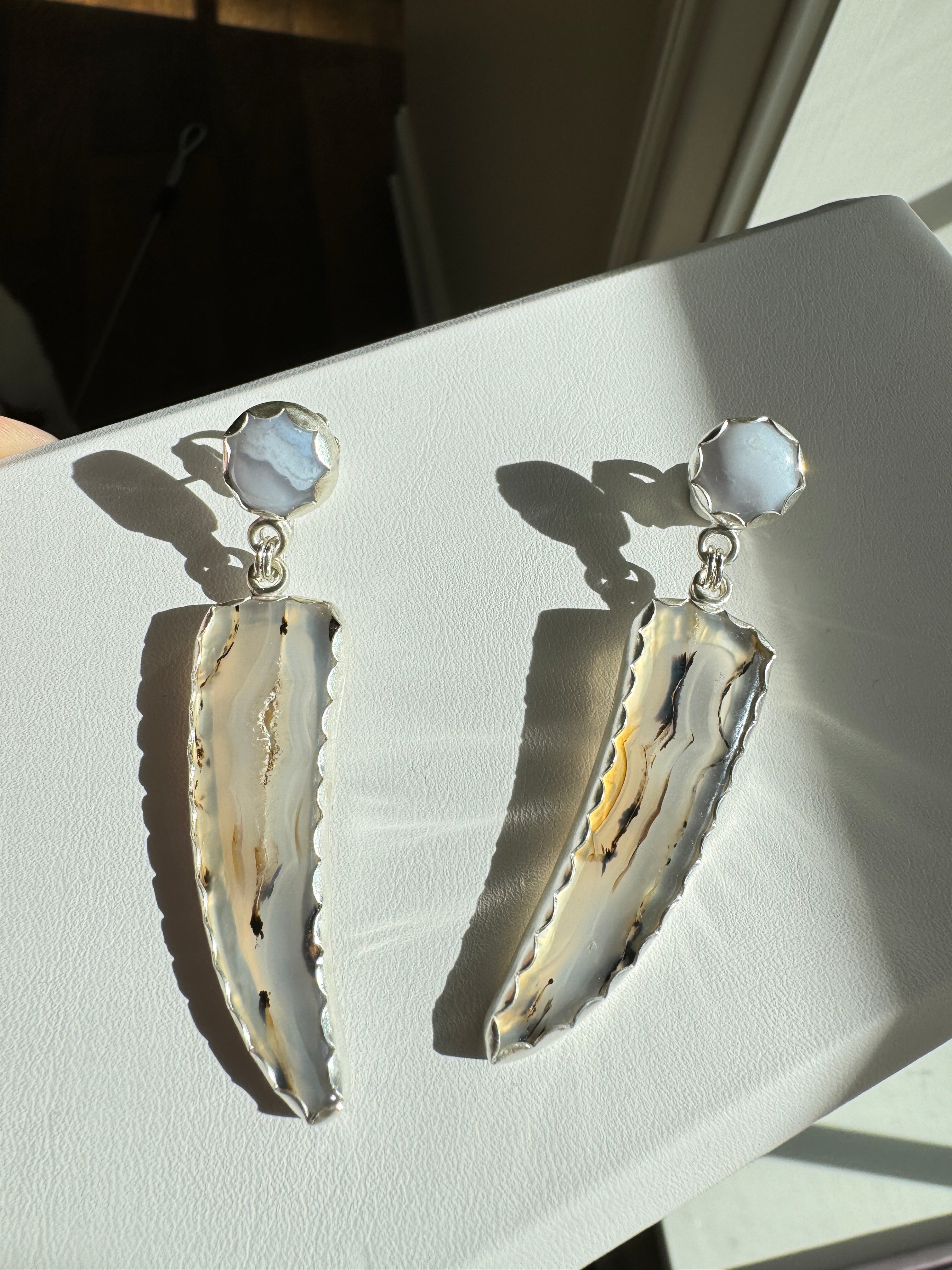 Gorgeous Montana Yellowstone Agate wrapped in fine silver and dangling from periwinkle chalcedony studs. This Montana agate was dug and cut by a Montana born female miner, making this pair extra special. These look stunning on, especially when the light hits the agate because I cut out most of the silver in the back to allow light to shine through and also keep these very lightweight and easy to wear. One of a kind pair.