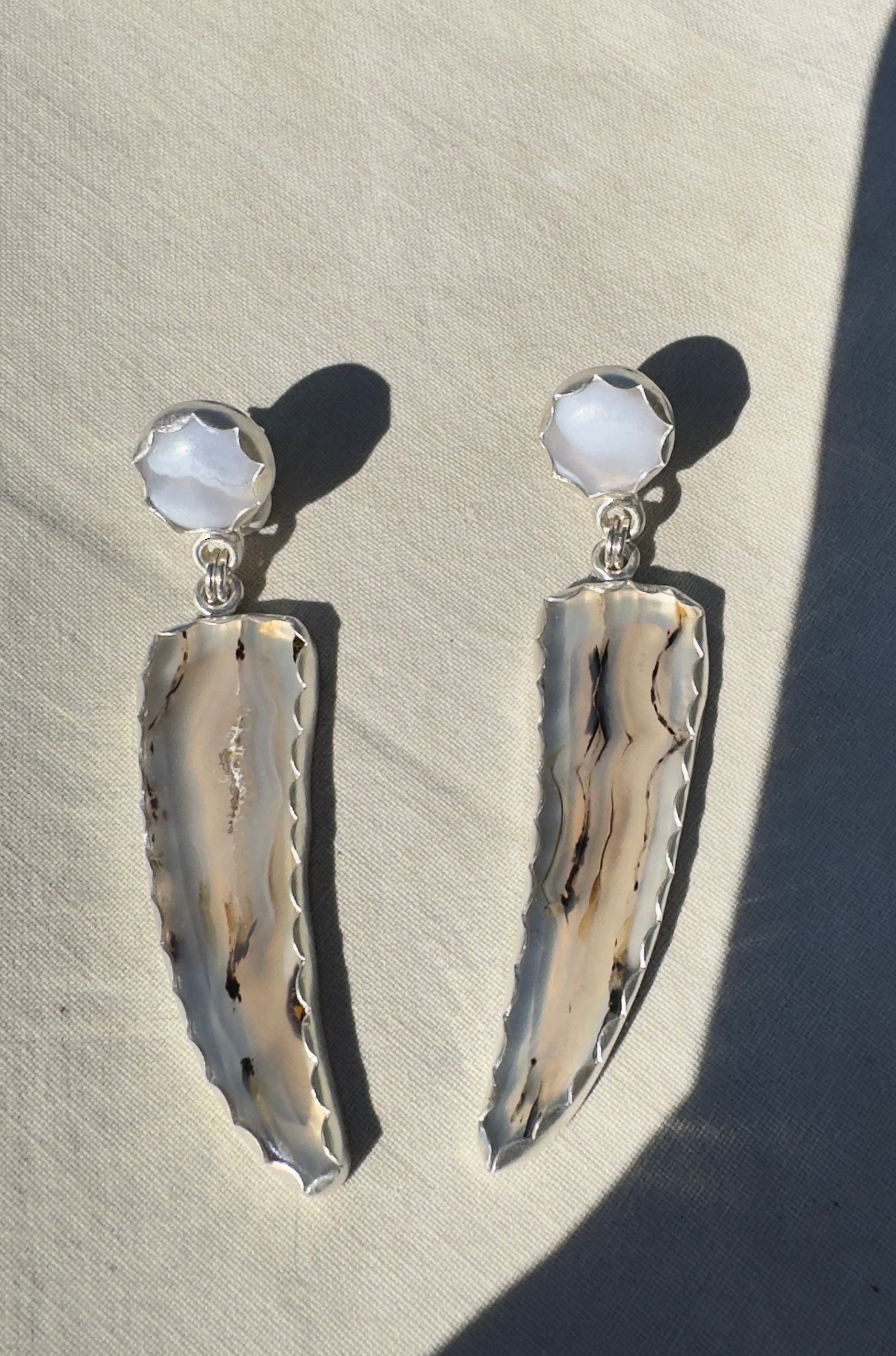 Gorgeous Montana Yellowstone Agate wrapped in fine silver and dangling from periwinkle chalcedony studs. This Montana agate was dug and cut by a Montana born female miner, making this pair extra special. These look stunning on, especially when the light hits the agate because I cut out most of the silver in the back to allow light to shine through and also keep these very lightweight and easy to wear. One of a kind pair.