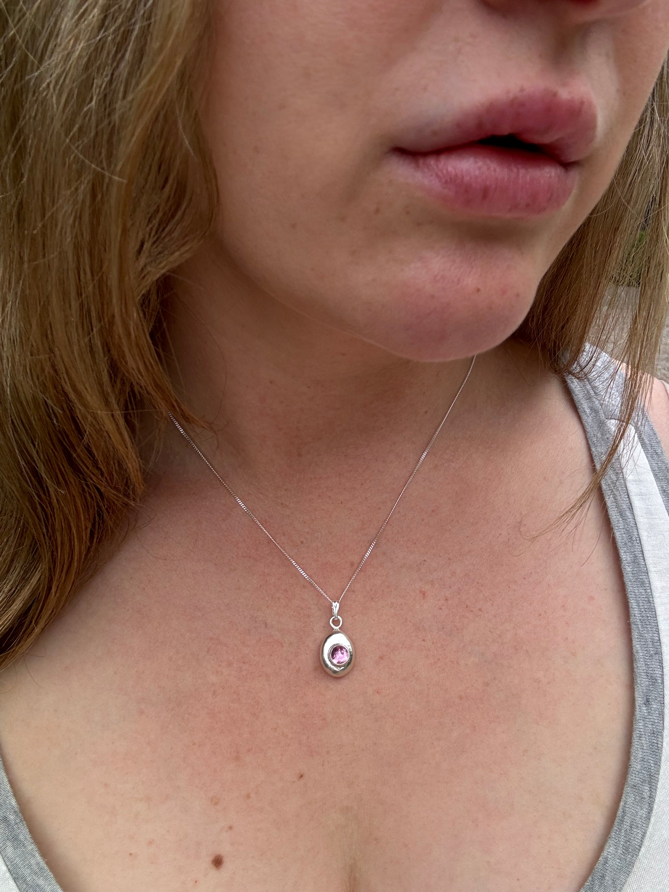 6mm Pink Sapphire (lab created) on a hand forged nugget of sterling silver. Choose between a 16” or 18” sterling silver diamond cut curb chain.