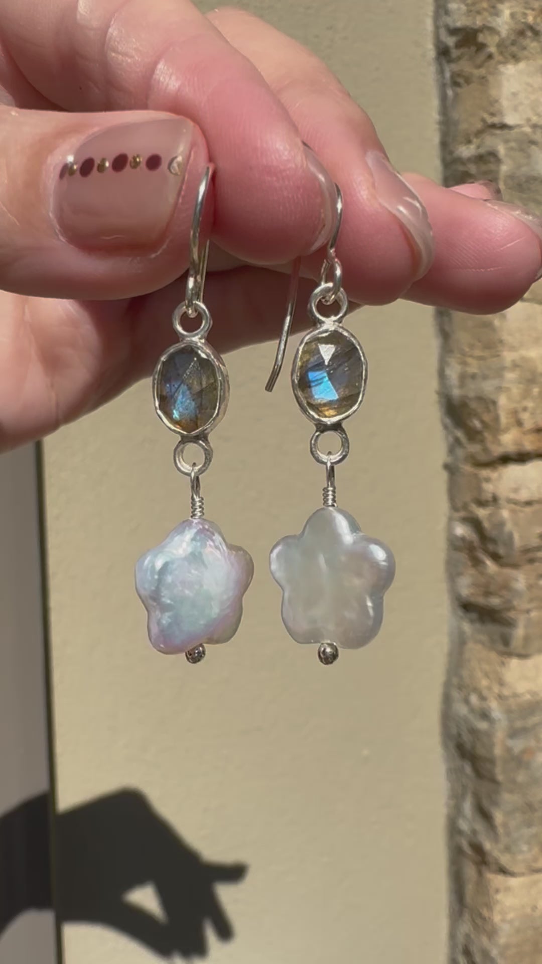 Icy blue labradorite set in a fine silver bezel on a sterling silver back with freshwater flower-shaped pearls dangling below.